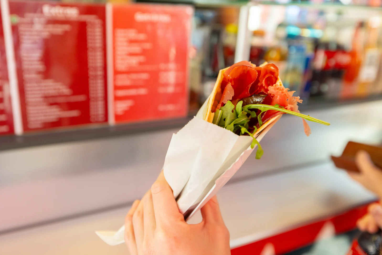 Frische Piadina im Papier, übergeben an einen Gast am Piadina Stand