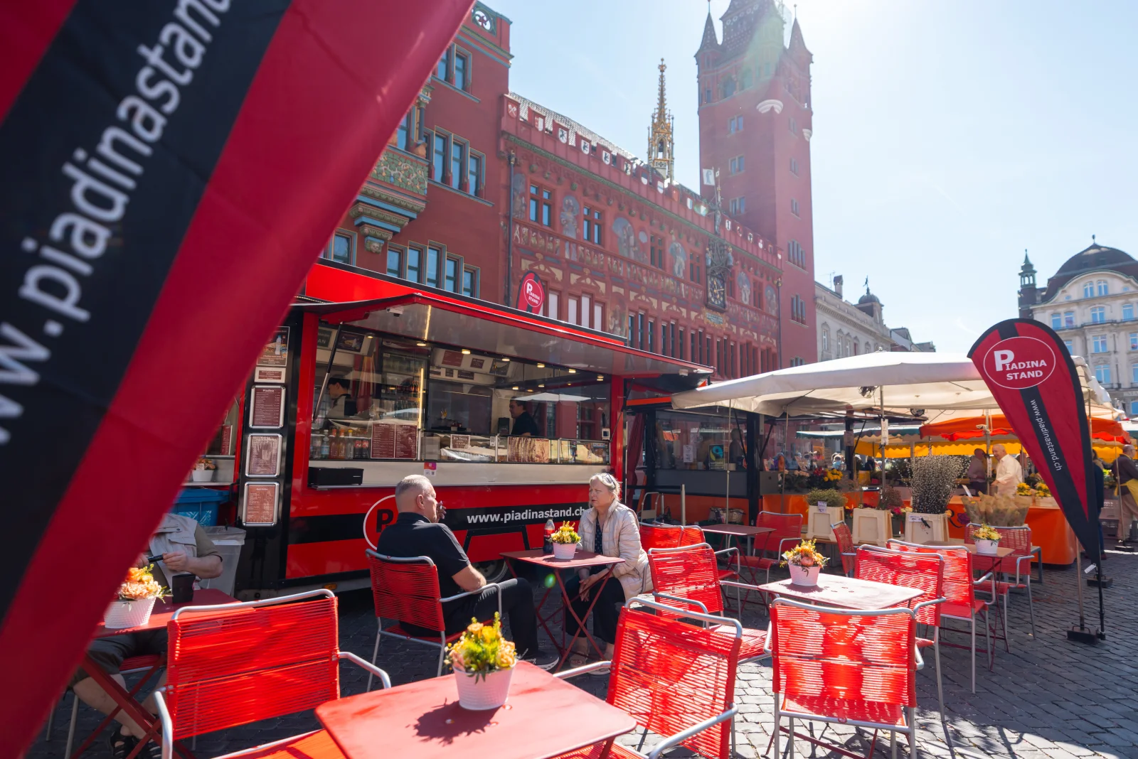 Roter Piadina Stand auf dem Basler Marktplatz mit Beach-Flag, Rathaus im Hintergrund, seit 2005 derselbe Standort